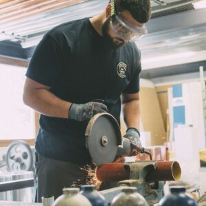 Ein Handwerker schneidet konzentriert ein Metallrohr mit einer Trennmaschine.